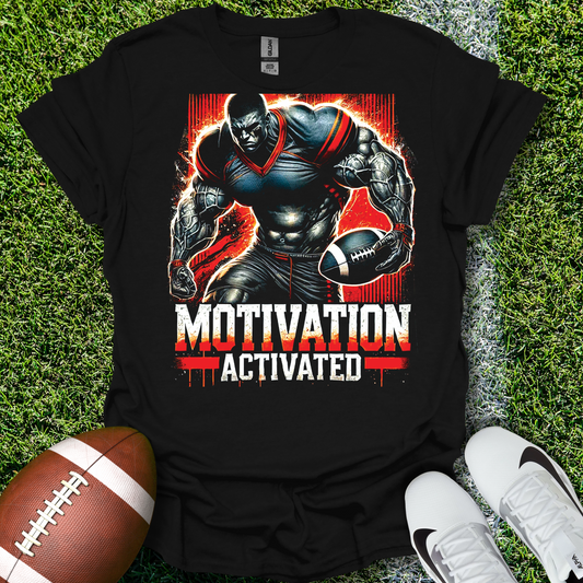 Black t-shirt with a football player graphic and 'Motivation Activated' text on grass with a football and shoes.