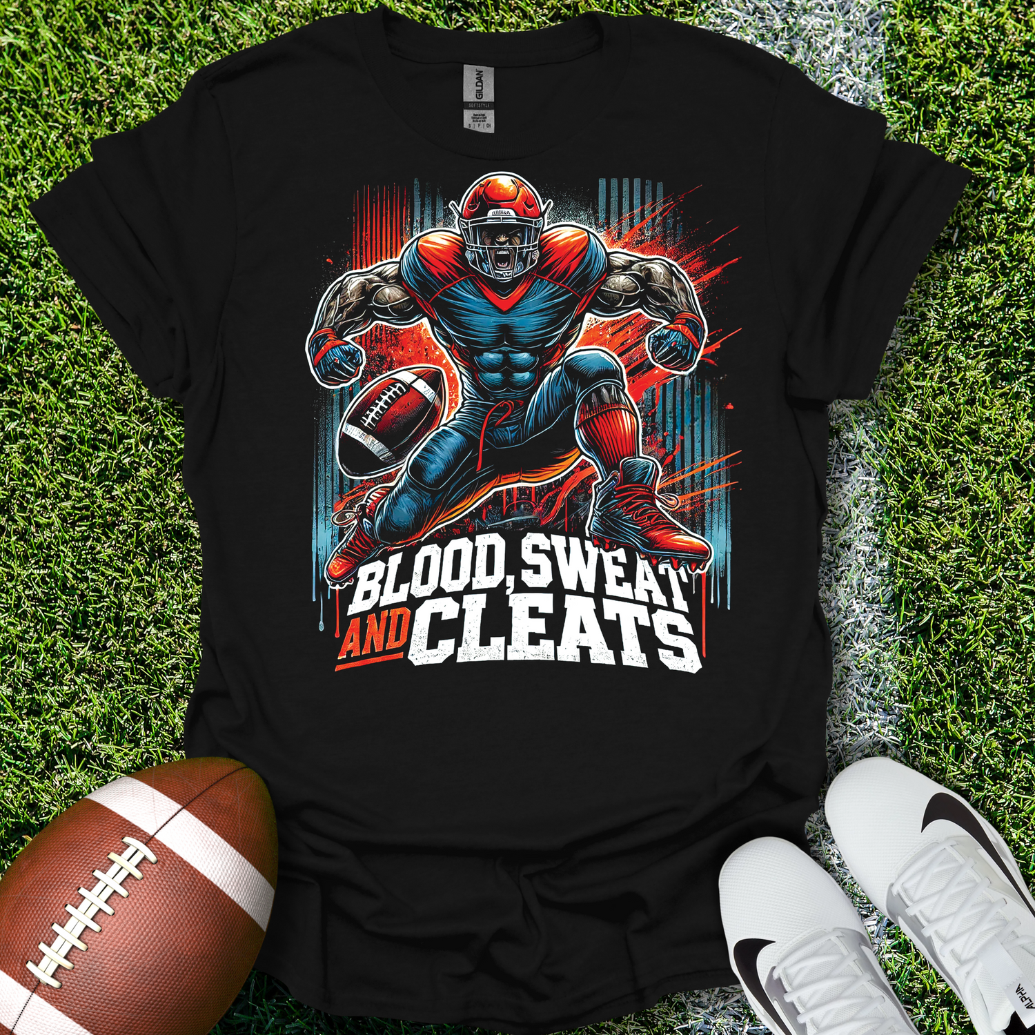 Black t-shirt with football player graphic and 'Blood, Sweat, and Cleats' text on grass with a football and shoes.