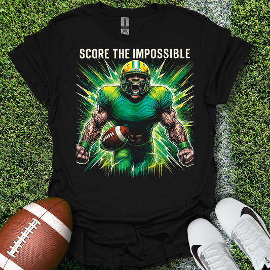 Black t-shirt with a football player graphic and 'Score the Impossible' text on grass, with a football and shoes.