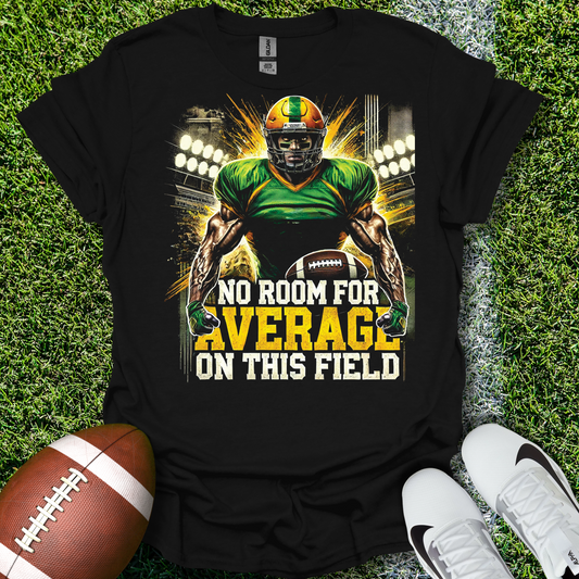 Black t-shirt with football player graphic and text 'No Room for Average on This Field' on grass with a football and shoes.