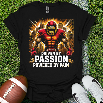 Black t-shirt with a football-themed graphic and text on grass with a football and shoes.