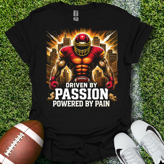 Black t-shirt with a football-themed graphic and text on grass with a football and shoes.
